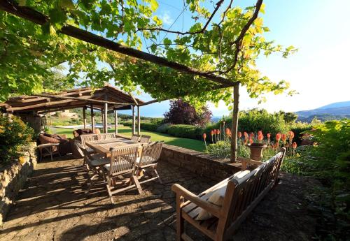 a patio with a table and chairs under a pavilion at Villa Riflessi di Fiesole - Piscina - Vista Firenze in Fiesole