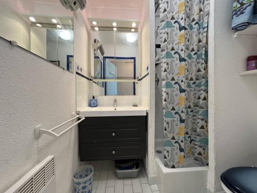 une salle de bain avec un lavabo et un rideau de douche dans l'établissement Studio cabine 2 couchages CAP D'AGDE NATURISME CN020-009, au Cap d'Agde