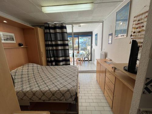 une chambre avec un lit et une télévision dans une pièce dans l'établissement Studio cabine 2 couchages CAP D'AGDE NATURISME CN020-009, au Cap d'Agde