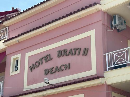 a sign on the side of a pink building at Brati II Beach Hotel in Arkoudi