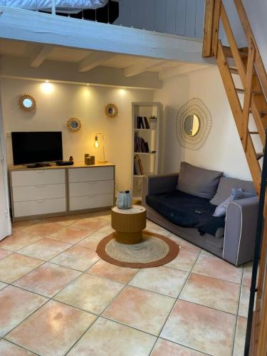 un salon avec un canapé et une table dans l'établissement La Tiny House YourHostHelper, à Narbonne
