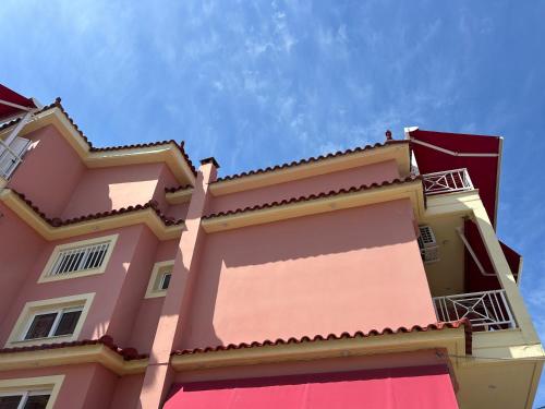 a pink building with a sky in the background at Brati II Beach Hotel in Arkoudi