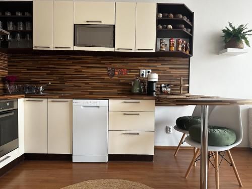 a kitchen with white appliances and a table in a room at Bali byt s parkovacím místem v centru města in České Budějovice