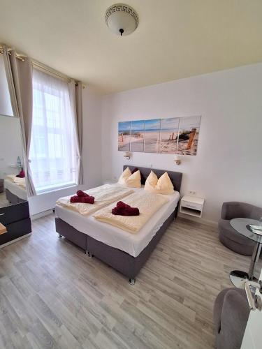 a bedroom with a large bed and a couch at Pension Kapitän Schmuck in Borkum