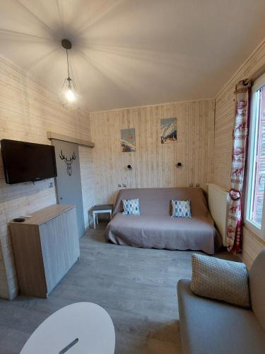 une chambre avec un lit et une télévision à écran plat dans l'établissement Charmant appartement - Le Mont Dore, à Le Mont-Dore