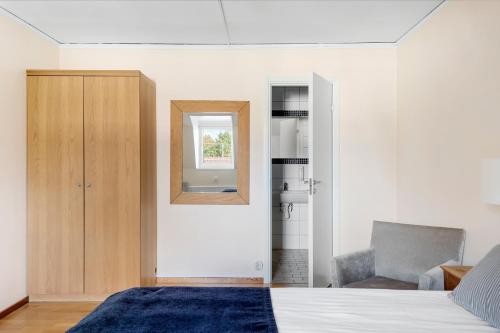 a bedroom with a bed and a mirror and a chair at Sure Hotel by Best Western Ojaby Herrgard in Växjö