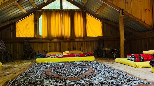 two beds in a room with a rug on the floor at NotOnMap - H2O House in Chamba