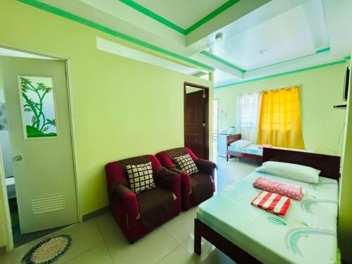 a living room with two chairs and a table at La Fela Pension House in Oslob