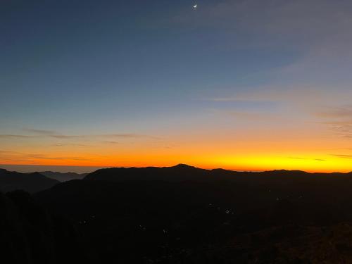 a sunset from the top of a mountain at The Shalam Resort श्रीकृष्ण शरणं मम in Lansdowne
