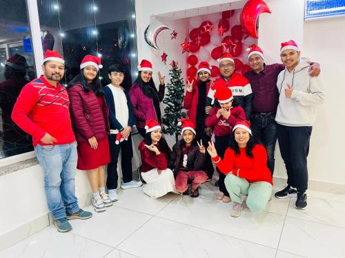 a group of people dressed in santa hats posing for a picture at The Shalam Resort श्रीकृष्ण शरणं मम in Lansdowne