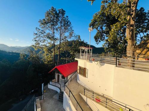 a balcony of a building with a red roof at The Shalam Resort श्रीकृष्ण शरणं मम in Lansdowne