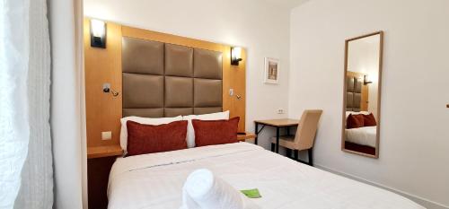 a hotel room with a large bed and a mirror at Hotel de France 18 in Paris