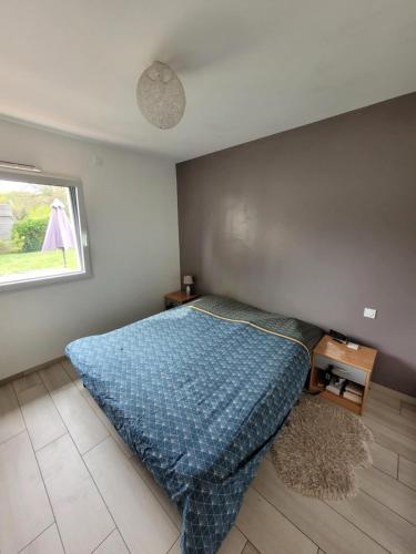 une chambre avec un lit avec une couette bleue dans l'établissement Maison récente 200m2 proche du circuit du Mans au calme, à Changé