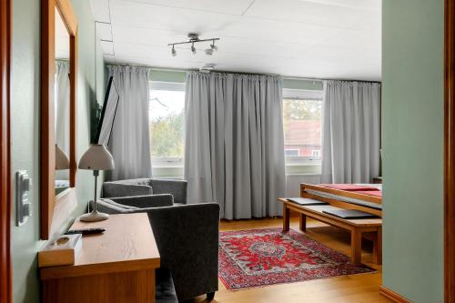 a living room with a desk and a chair at Sure Hotel by Best Western Ojaby Herrgard in Växjö