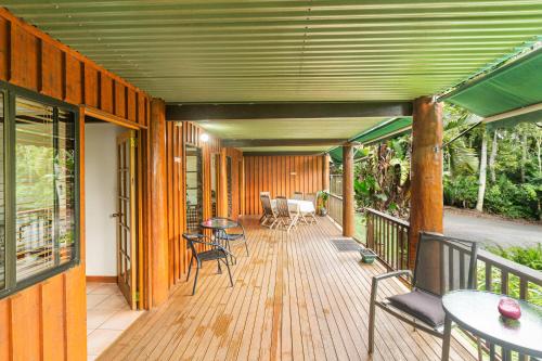 a wooden deck with chairs and tables on it at Atherton Blue Gum in Atherton