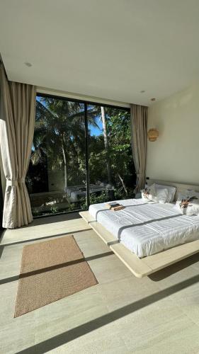 a bedroom with two beds and a large window at Seaview Villa Ganesha in Ko Phangan