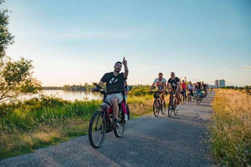a group of people riding bikes down a road at Twin room along the river Po in a BB in Porto Viro in Porto Viro