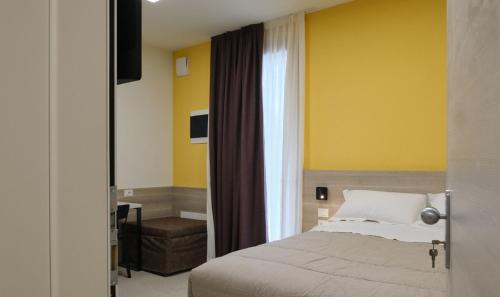 a bedroom with a bed and a yellow wall at Double room with special accesses in a BB in Porto Viro in Porto Viro