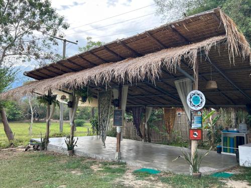 a hut with a straw roof and a sign at Blue stone in Pai