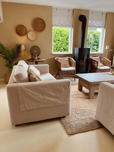 a living room with a white couch and a table at Vakantiewoning in villapark de oesterbaai 113 in Wemeldinge