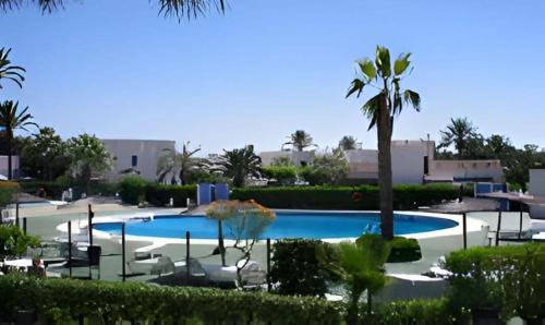 duży basen z palmami w ośrodku wypoczynkowym w obiekcie Puerto Rey Apartamento 150m playa w mieście Los Amarguillos