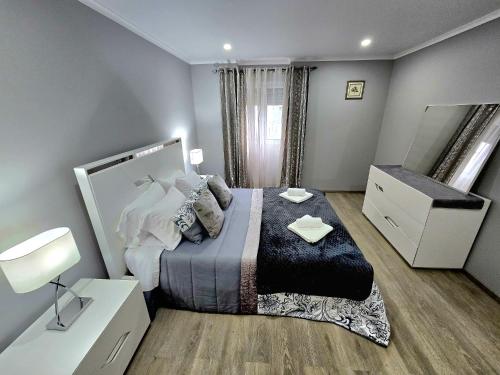 a bedroom with a bed and a dresser and a mirror at São Brás Home in Porto Formoso