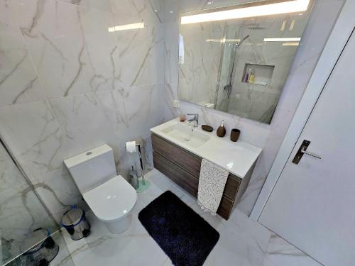 a white bathroom with a toilet and a sink at São Brás Home in Porto Formoso