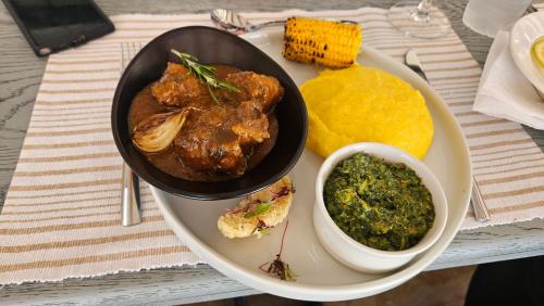 a plate of food with meat and a bowl of sauce at Matsila Game Lodge in Thohoyandou