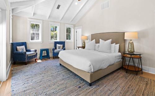 a bedroom with a large bed and two chairs at WaterColor Escape in Santa Rosa Beach