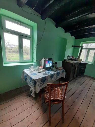 a room with a table with a television and a chair at Həzrətqulu Qonaq evi - Rahat Ailəvi Fərdi Çoxotaqlı in Quba
