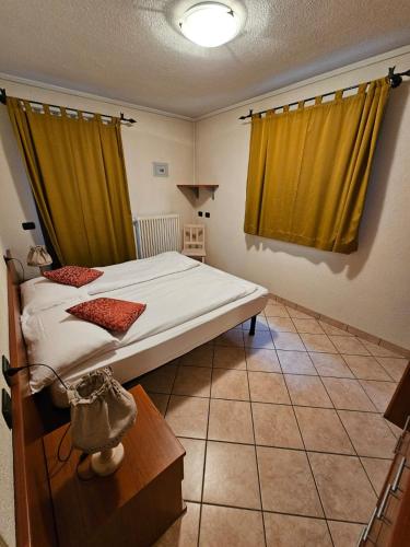 a bedroom with a bed and a yellow curtain at Chalet La Rugiada in Bormio