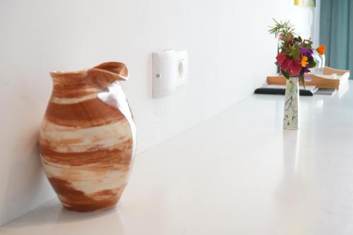a vase sitting on a table next to a vase with flowers at Bougainville Bay Hotel in Sarandë
