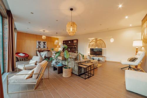 a living room with white chairs and a couch at Quinta Verde Esperança in Vila Nova de Gaia