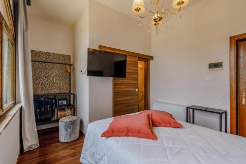 a bedroom with a bed with a red pillow at Villa Lecchi Hotel Wellness in Colle Val D'Elsa