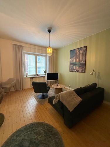 un salon avec un canapé noir et une table dans l'établissement Cozy studio in Punavuori, à Helsinki