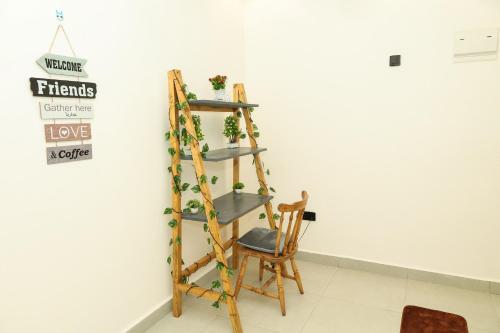 a ladder shelf with plants on it next to a chair at Nyali Vale residence in Mombasa