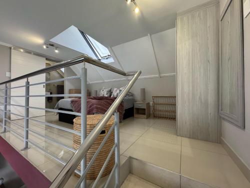 1 dormitorio con 1 cama y una escalera en una casa en Stylish Loft apartment in the heart of Durbanville, en Durbanville