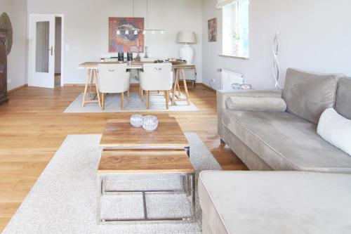 a living room with a couch and a table at Techts Apartmenthaus in Timmendorfer Strand