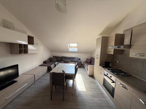 a kitchen and living room with a table and a couch at Rétrohome in Sulmona