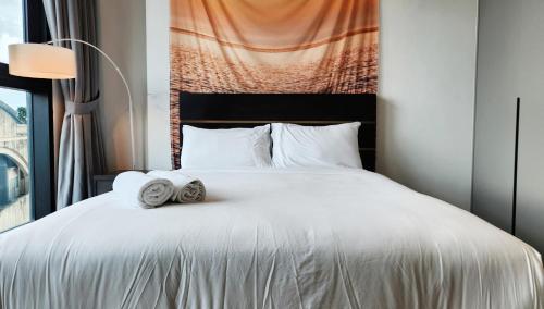 a bedroom with a white bed with towels on it at Opus Residences Kuala Lumpur by Infini Suites in Kuala Lumpur