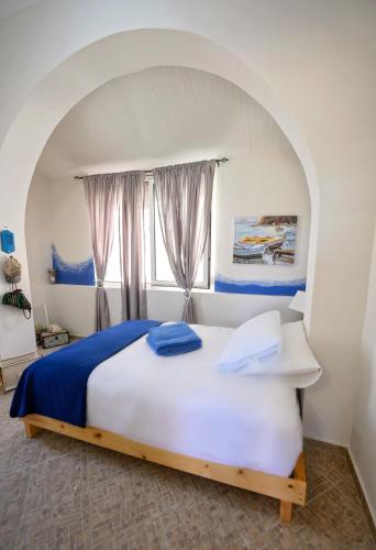 a bedroom with a large bed with a window at Maria's Private Residence in Kalymnos