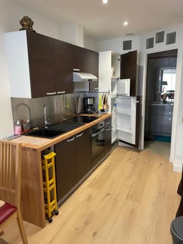 Il comprend une cuisine avec du parquet et des placards marron. dans l'établissement Maison plein centre-ville ménage inclus, à Saint-Hilaire-de-Riez