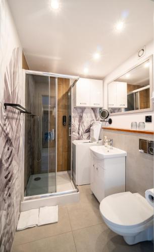 a bathroom with a shower and a toilet and a sink at Kawalerka Słoneczna w Centrum in Ostrów Wielkopolski