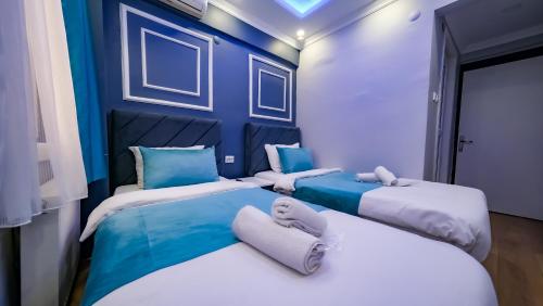 two beds in a room with blue walls at Grand Bona Sera Hotel in Istanbul