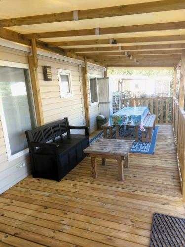 une véranda avec un banc et une table dans l'établissement Mobil Home Denise et Michel, à Lit-et-Mixe