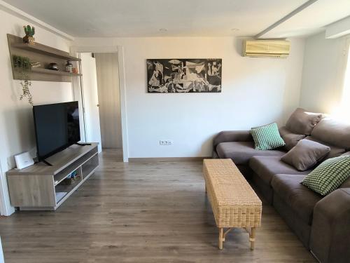 a living room with a couch and a flat screen tv at La Esencia de Delicias in Zaragoza