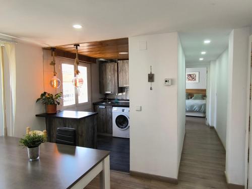 a kitchen and living room with a table and a stove at La Esencia de Delicias in Zaragoza