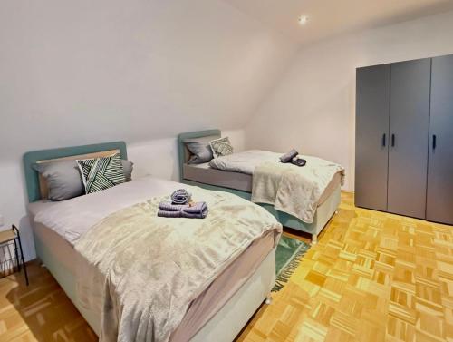 锡根GRÜN möbliertes Wohnen auf Zeit mit 2 Schlafzimmern und 65 Zoll TV的一间卧室配有两张床和橱柜