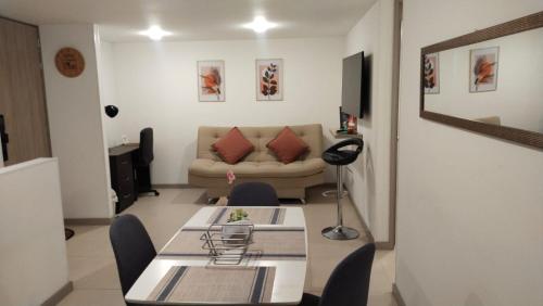 a living room with a table and a couch at Apartment in Envigado with a pool in Envigado