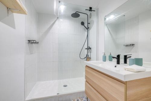 une salle de bain blanche avec un lavabo et une douche dans l'établissement L'éclat des 5 Avenues, à Marseille